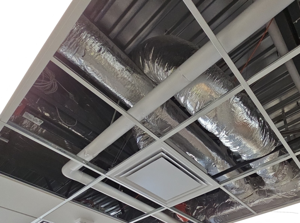 Flex duct installation mistake, a 10 foot flex run bent over another duct and lying on the ceiling grid.