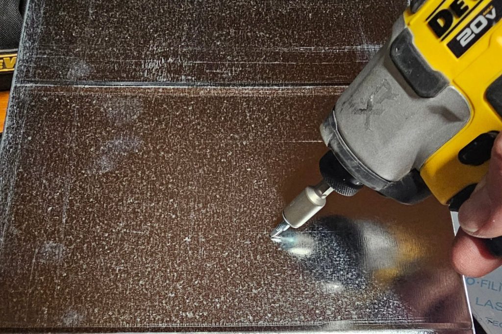 A nut setter in an impact driver driving a hex head screw into rectangular duct